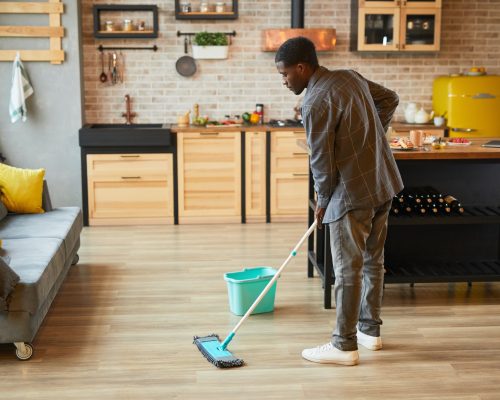 Young Man Cleaning Floors at Home